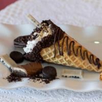 Oreo Explosion  · Waffle cone dipped in chocolate covered with crushed oreos, filled with oreo cheesecake topp...