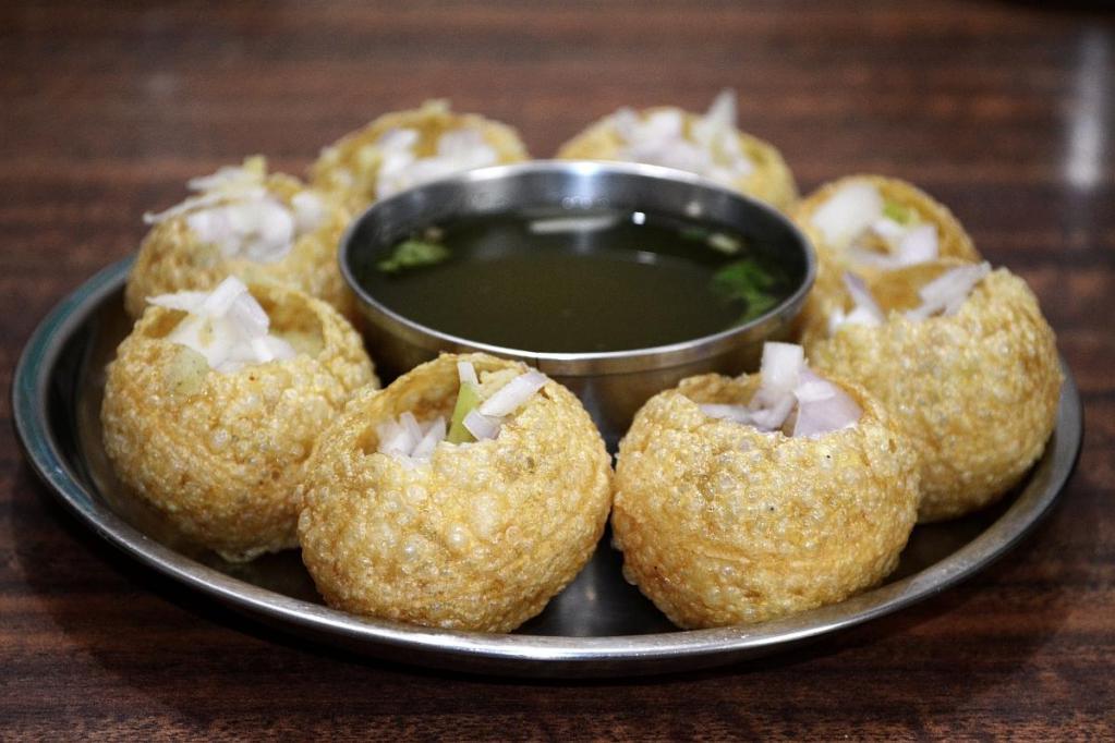 AP9. Pani Puri · Six puffed puri filled with potato, chickpeas, tamarind chutney and served with chilled spicy water.