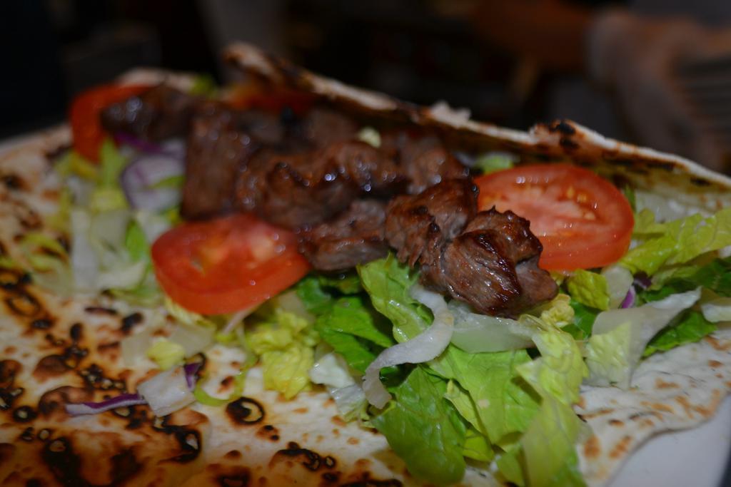Beef Shish Kebab Wrap · Tender cubes of beef marinated in our chef's unique seasonings and char-grilled to perfection on skewers. Served with lettuce, onion and sliced tomatoes with red spicy or white cacik sauce on the side.