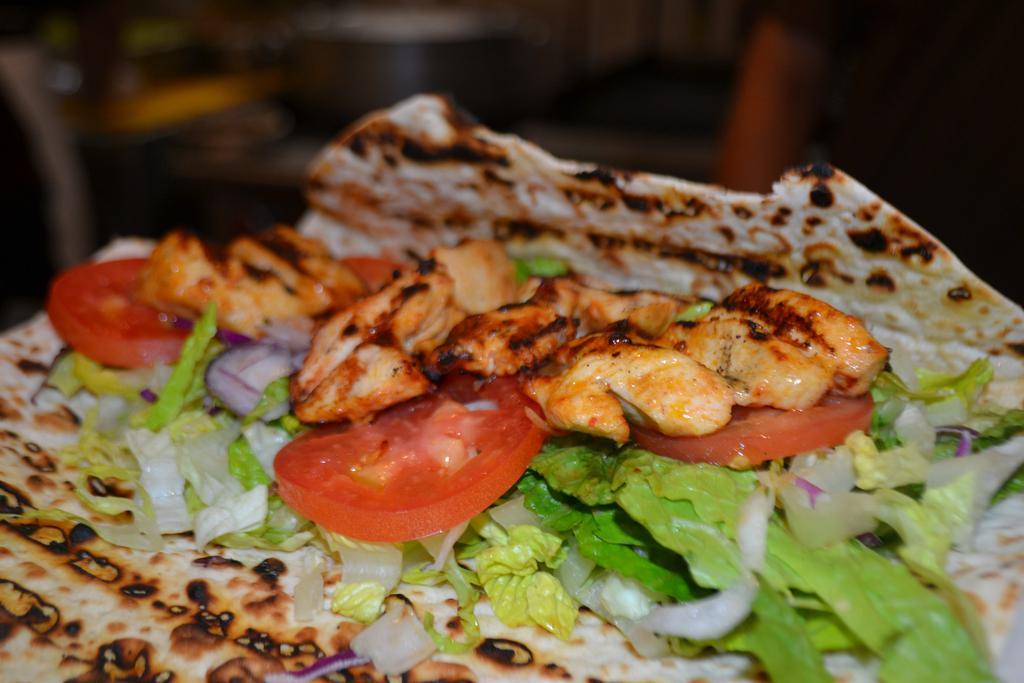 Chicken Shish Kebab Wrap · Tender cubes of chicken marinated in our chef's unique seasonings and char-grilled to perfection on skewers. Served with lettuce, onion and sliced tomatoes with red spicy or white cacik sauce on the side.