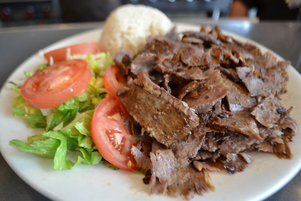 Gyro · Layers of marinated ground meat, wrapped around the large vertical split and grilled in front of an ingenious herd of charcoal fire. Served with salad and side.