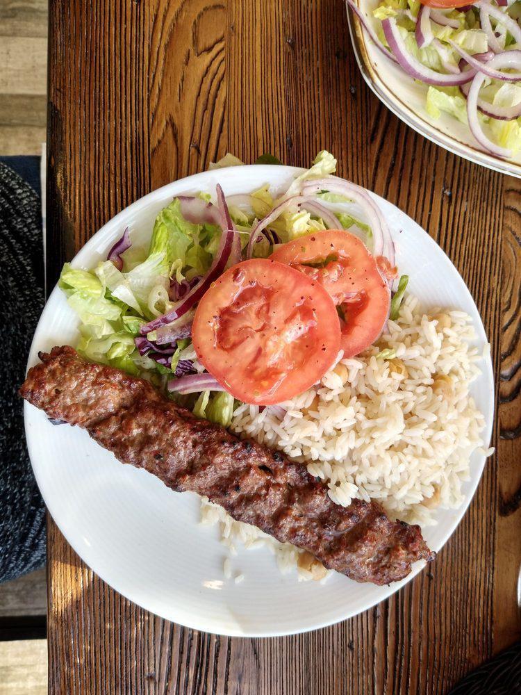 Adana Kebab · Ground lamb flavored with red bell peppers slightly seasoned with paprika and grilled deliciously on skewers. Served with salad and side.