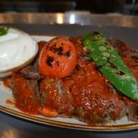 Iskender Kebab · Doner kebab served over croutons topped with fresh tomato sauce and a healthy portion of fre...