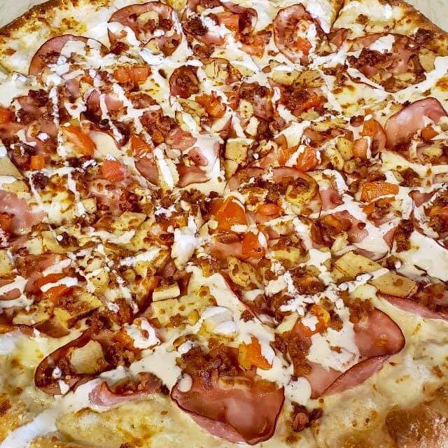 Chicken Bacon Ranch Pizza · Garlic chicken, bacon crumbles, Canadian bacon and cooked tomatoes on our buttermilk ranch base with a drizzle of ranch on top.