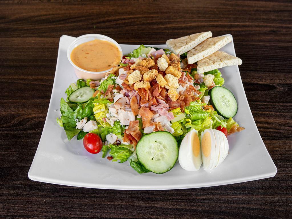 Cobb Salad · Black forest ham, oven classic turkey, bacon crubles, hard boiled egg, blue cheese crumbles, shredded carrot, cucumber, cherry tomato and croutons served on a bed of crisp romaine lettuce with Thousand Island dressing.