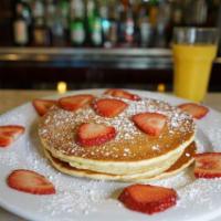 Strawberries and Cream Pancakes · 3 buttermilk pancakes topped with fresh strawberries and whipped cream.
