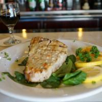 Grilled Sword Fish over fresh spinach · 