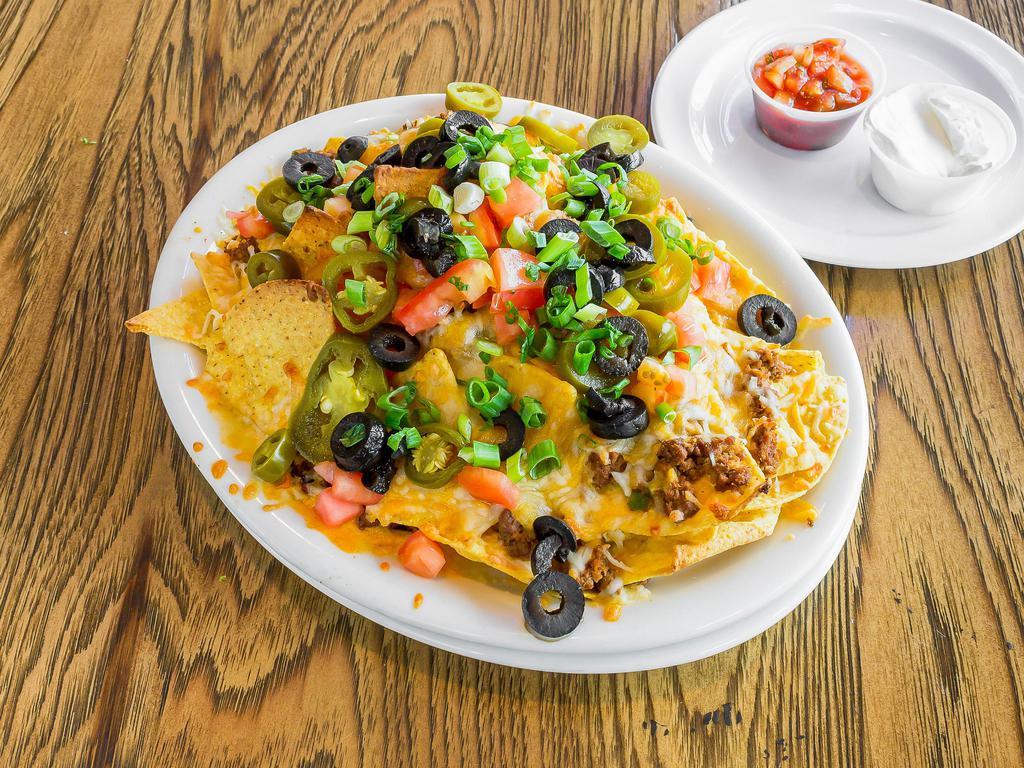 Nachos · Ground beef or chicken, fresh cooked corn tortilla chips, cheddar-jack cheese, olives, tomatoes, jalapeños and sour cream with salsa.