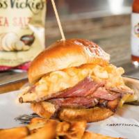 Mac N’ Brisket Sandwich · Delicious smoked brisket, topped with mac & cheese, cheddar cheese and BBQ sauce.