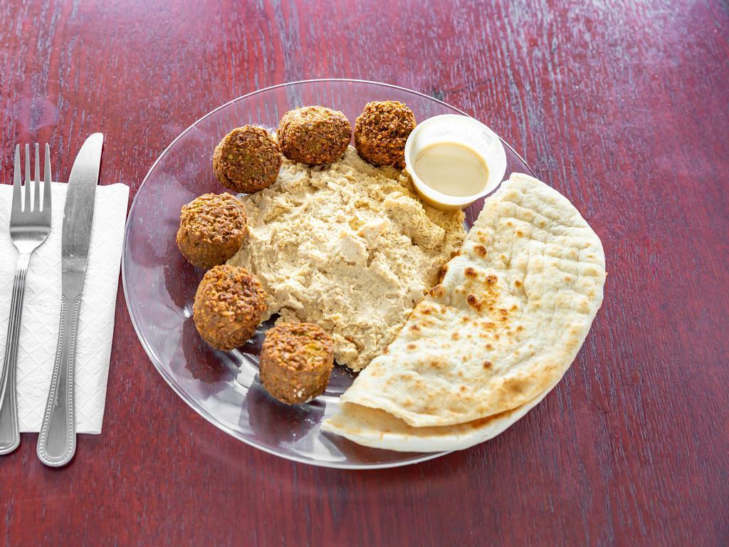 Falafel Dinner · Fresh homemade falafel,lettuce,tomatoes topped with humus,pita bread,salad and tahini sauce on the side