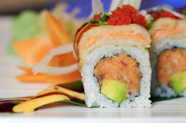 Fusion Roll · Spicy tuna, avocado, scallion inside topped with tempura salmon, tobiko spicy mayo and eel sauce.