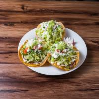 Unidad Tostada · Unit.  Frijoles, pico de gallo, crema, queso y guacamole. Beans, pico de gallo, cream cheese...