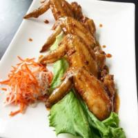 Nha Trang Wings · Chicken wings are fried and tossed in a blend of fish sauce and garlic, served with a side o...