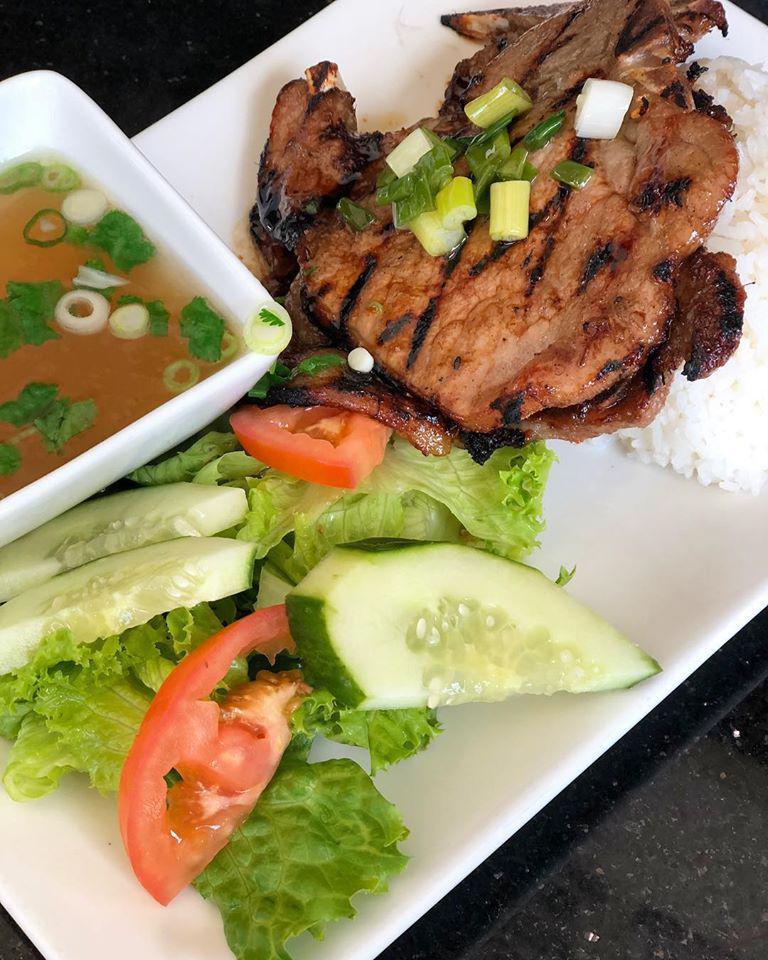 Grilled Pork Chops · Pork chops marinated in an oyster sauce recipe, with shallots, and garlic. Served with rice, lettuce, cucumbers, tomatoes, and pickled vegetables.
