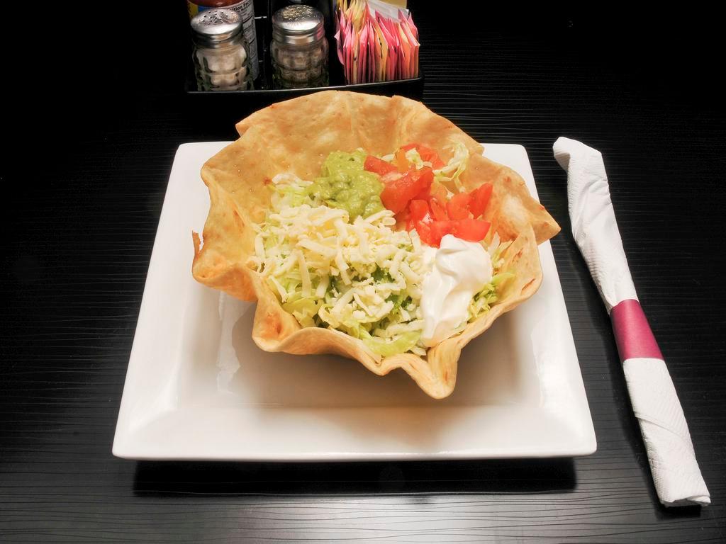 Taco Salad Deluxe · A crisp flour tortilla filled with chicken or beef, beans, lettuce, tomatoes, shredded cheese, guacamole and sour cream.