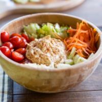 Veggie Hummus Quinoa Bowl · Ripe cherry tomatoes, shredded carrots, chopped spinach, red onions and cucumber slices on a...