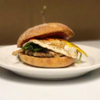 The Sausage Sammy · Fried egg, breakfast sausage, mozzarella cheese, roasted red pepper sauce and spinach on a b...