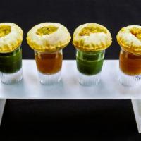 Pani Puri · Puffed hollow pastry pockets served with seasoned potatoes. Served with cooling mint and tan...