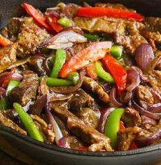 Pepper Steak · Steak strips (Beef Tenderloin Tips) cooked with peppers and onions until all the liquid from the beef is evaporate and all the flavor seal in the strips. DO NOT order if you are expecting a juice RED steak. This is NOT. It is cooked this way on purpose. Look at the picture, very well done and very dark meat.  If you have a question please call us! .