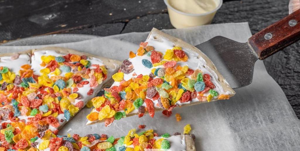Fruity Pebbles Pie · Sweet Dough coated with marshmallow fluff topped with fruity pebbles and confetti sugar. Comes with our famous Zambayone sauce (Ice Cream Sauce).