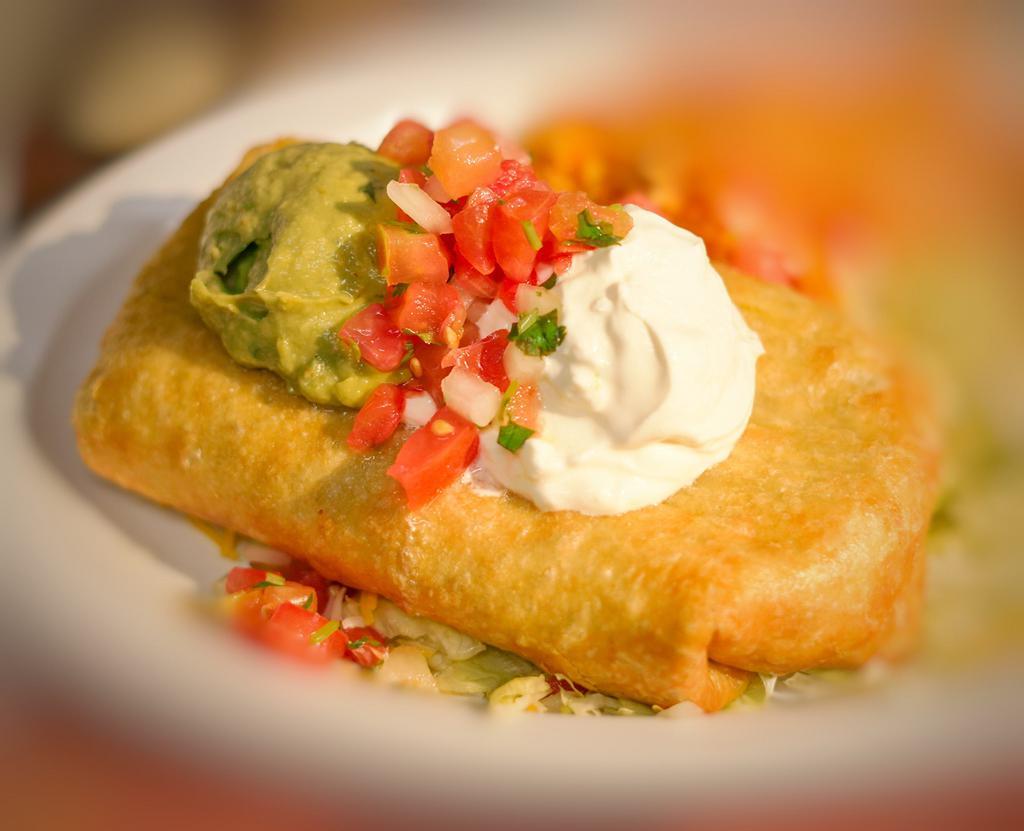 Chimichanga · Deep fry burrito with your choice of meat with rice, beans and cheese inside and topped with pico de gallo, sour cream, guacamole and cheese, serve with rice, refried beans garnished with cheese and tortilla chips