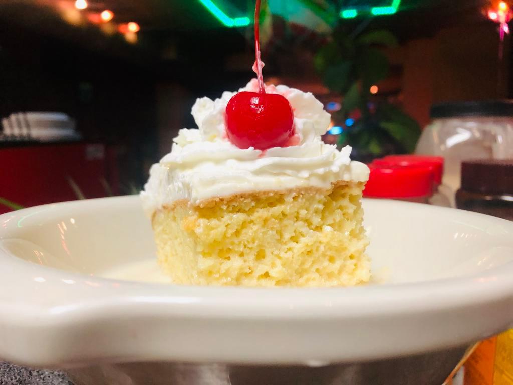 TRES LECHES CAKE  · Three milk soaked vanilla sponge cake topped with whipped cream