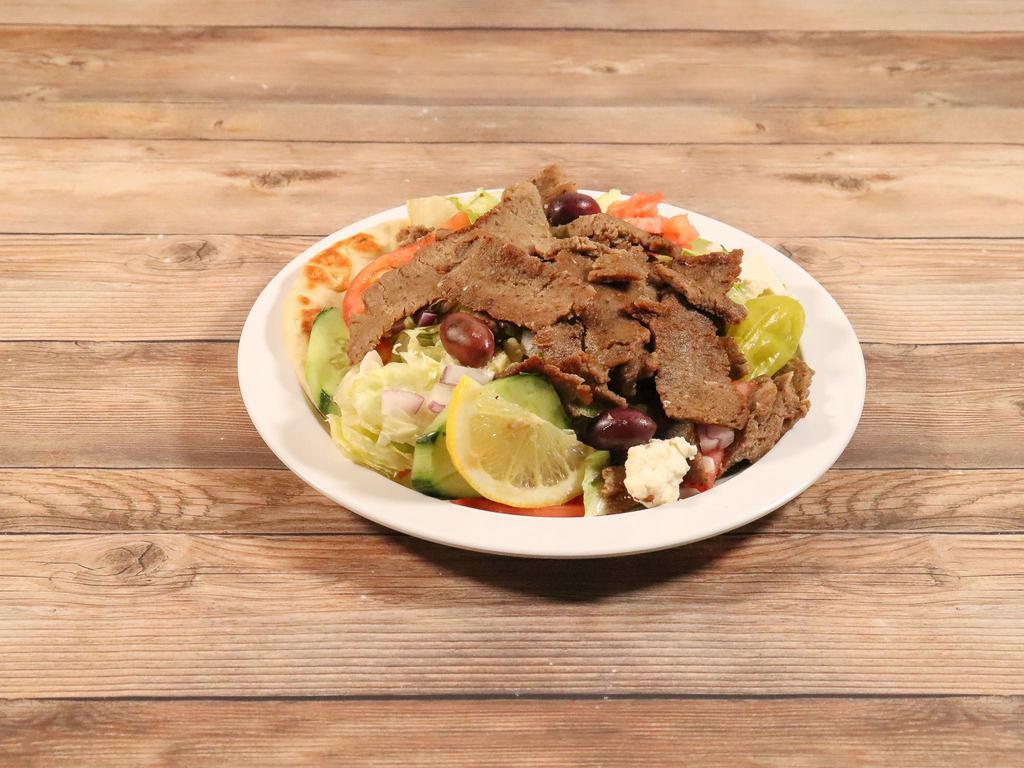 Gyro Salad · Made of lettuce, tomatoes, onions, cucumber, black olives, malt vinegar, oregano, feta cheese and tzatziki sauce as a dressing and gyro meat on top.