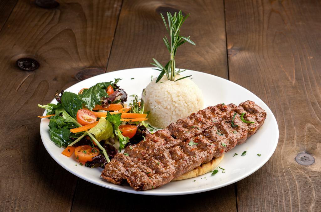 Adana Kebab · Hand chopped lamb mixed with red bell peppers, seasoning, and grilled on skewer. Served with house salad and rice.