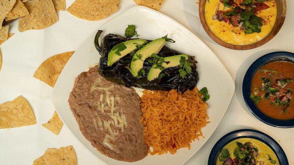 Grilled Poblano · Fresh-grilled poblano pepper stuffed with Monterey cheese and your choice of steak or chicken fajita. Includes avocado slices. Served with rice and beans.