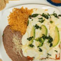 Enchiladas de espinacas · 2 spinach and onion enchiladas topped with sour cream. Served rice and beans and garnished w...