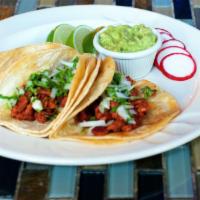 Carne Enchilada Taco · Three soft corn tortillas topped with cilantro and onion, served with rice, beans, and guaca...