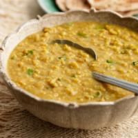 Dal Tarka · Moong dal cooked with chopped ginger, garlic, onions and tomatoes and garnished with cilantr...