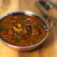 Goat Curry · Goat meat (with bones) cooked with ginger, garlic, onions, gravy and fresh tomato sauce. Ser...