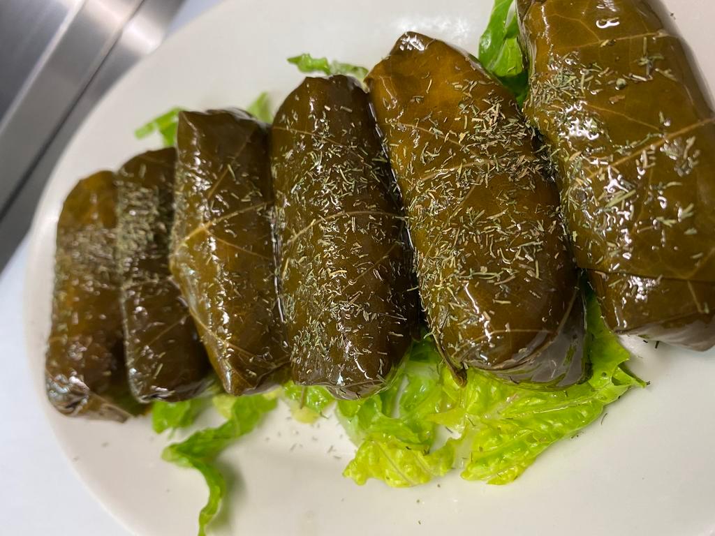 Dolmades · Vegan. 6 pieces. Rice & herb stuffed grape leaves, served with a side of tzatziki.