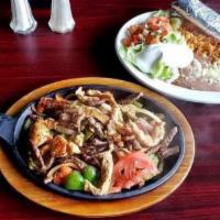 Chicken and Steak Fajita · Served with steak and chicken. Sauteed with bell peppers, onions, and tomatoes on a sizzling...