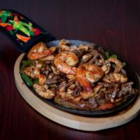 Texas Fajita · Steak, chicken, and shrimp. Sauteed with bell peppers, onions, and tomatoes on a sizzling pl...
