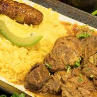 Seco de Chivo · Goat stew served with rice, fried sweet plantain and avocado.