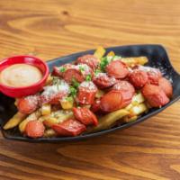 Salchipapas · French fries tossed in garlic and Parmesan cheese topped with cilantro and pink sauce on the...