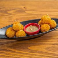 Yuca Croquettes · ( 8 ) Mashed yuca stuffed with mozzarella covered in light panko crust. Served with garlic l...
