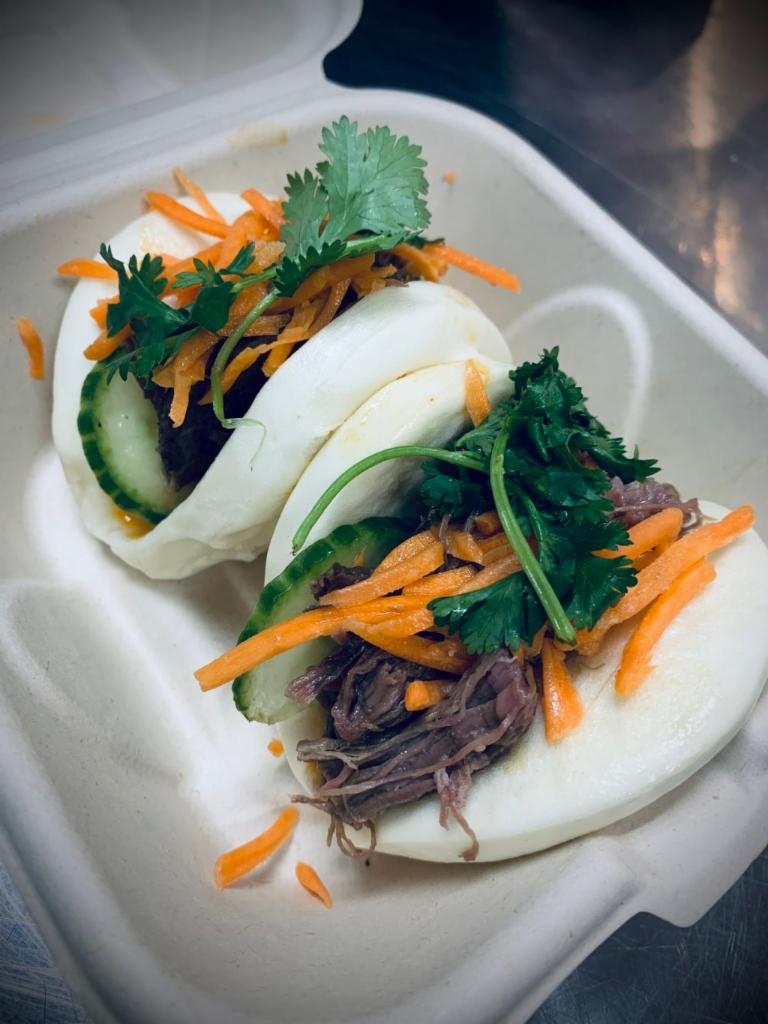BONMi Bao · Two fluffy baos filled with choice of pulled pork, tofu, BBQ pork belly (+$1), or 18 hour beef (+$1), with spicy mayo, pickled carrots, cucumber & cilantro.
