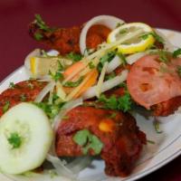 TANDOORI CHICKEN · Chicken on bone marinated in sauce cooked in clay oven. Served with rice.