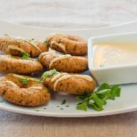 Falafel · Ground garbanzo and fava beans, seasoned and fried and served with tahini sauce. Vegan.