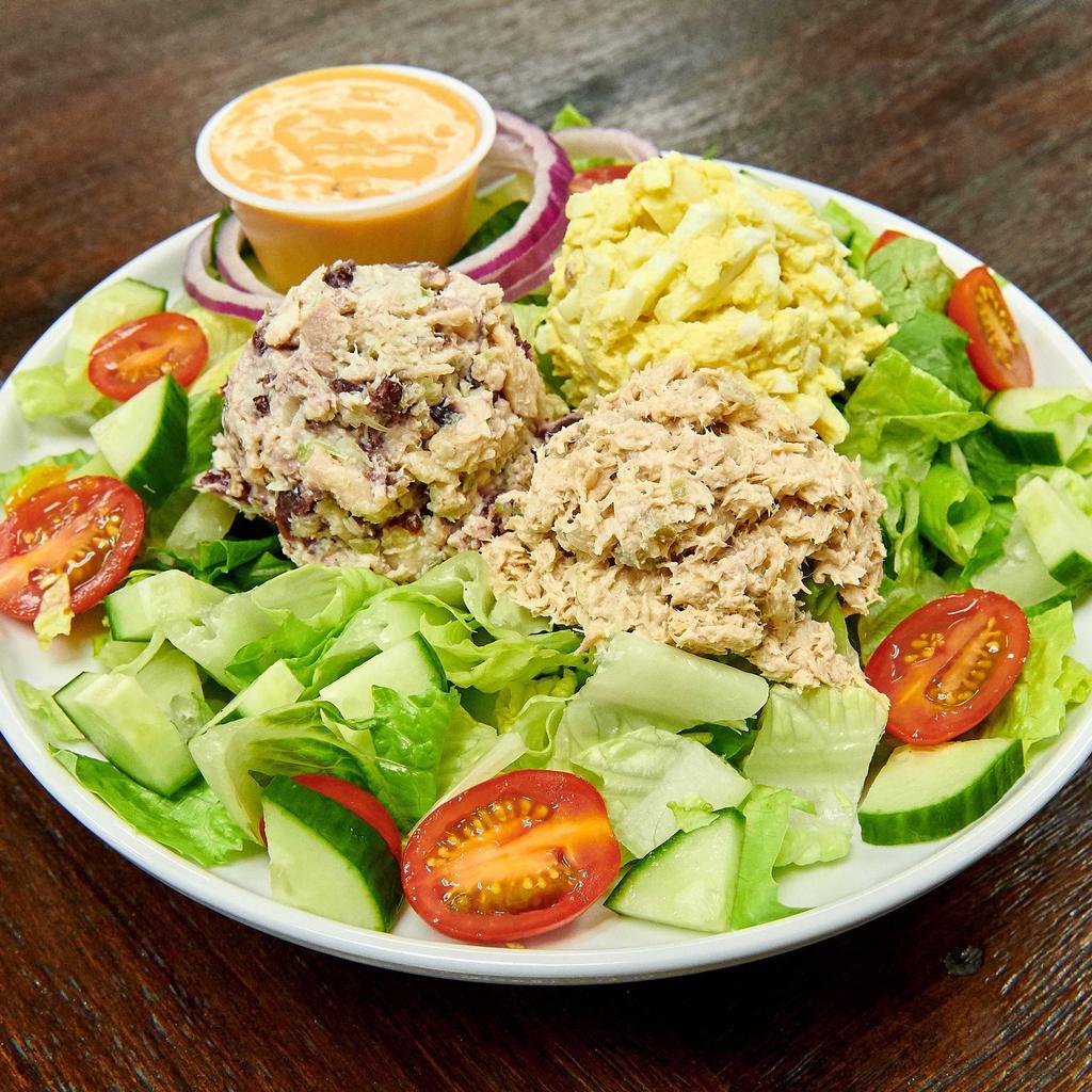 The Trio Salad · Chicken salad, tuna salad, egg salad, on a bed of lettuce, cucumbers and tomatoes.