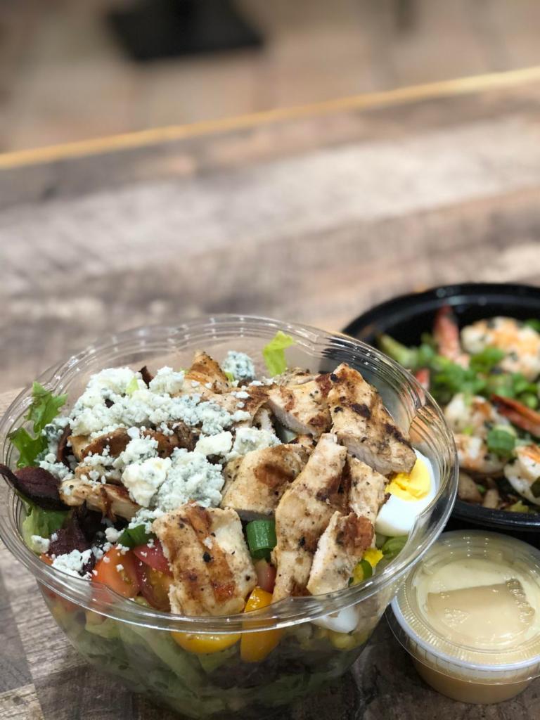 Traditional American Cobb Salad · Chicken, avocado, corn, green onion, hard boiled egg, bacon, cherry tomato & crumbled blue cheese served over romaine with a side of honey mustard vinaigrette.
