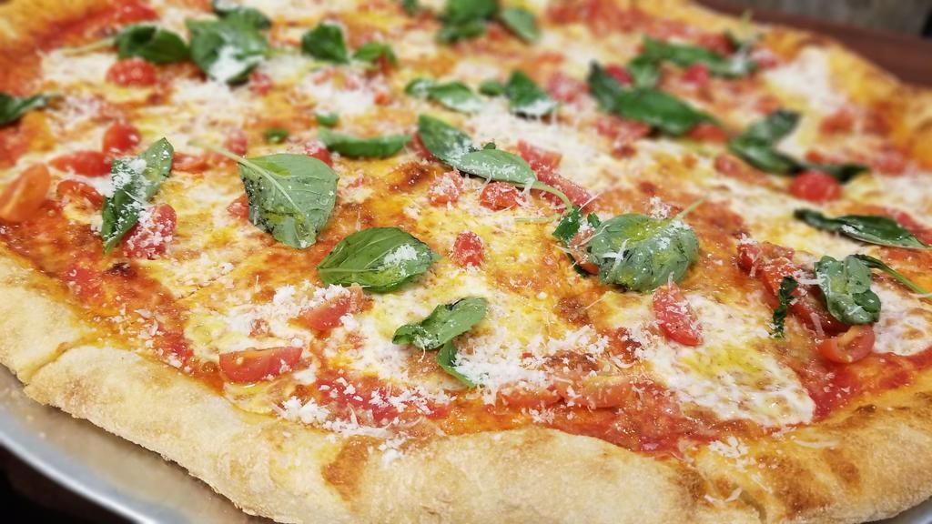 Margherita Pizza · Topped with Fresh Mozzarella, Basil, Cherry Tomatoes; Drizzled with Extra Virgin Olive Oil and sprinkled with fresh Parmesan cheese