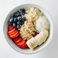 Açaí Bowl · Frozen Açaí Berry puree blended with banana and pineapple. Topped with fresh sliced bananas,...