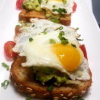 Avocado Toast Sandwich Breakfast · 2 Eggs sunny side up, smashed avocado, cherry tomatoes  on multi-grain toast topped with sca...