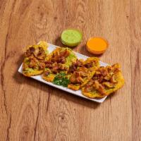 7. Tostones Con Guacamole Y Chicharron · Green plantain with guacamole and pork skin.