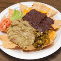 35. Guacamole Nachos · Homemade white corn tortilla chips covered with melted cheese, salsa, jalapenos, black beans...