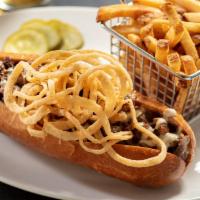 House Cheesesteak · chopped ribeye, white cheddar, house steak sauce, roasted garlic aïoli, fried onion strings.